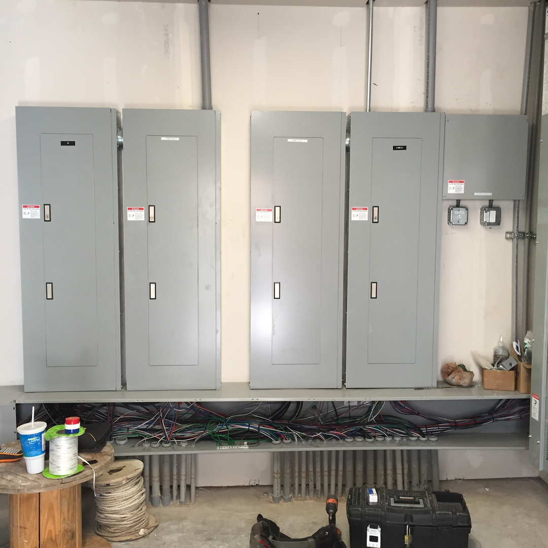 Commercial electrical room with multiple panelboards, conduit, and organized power distribution