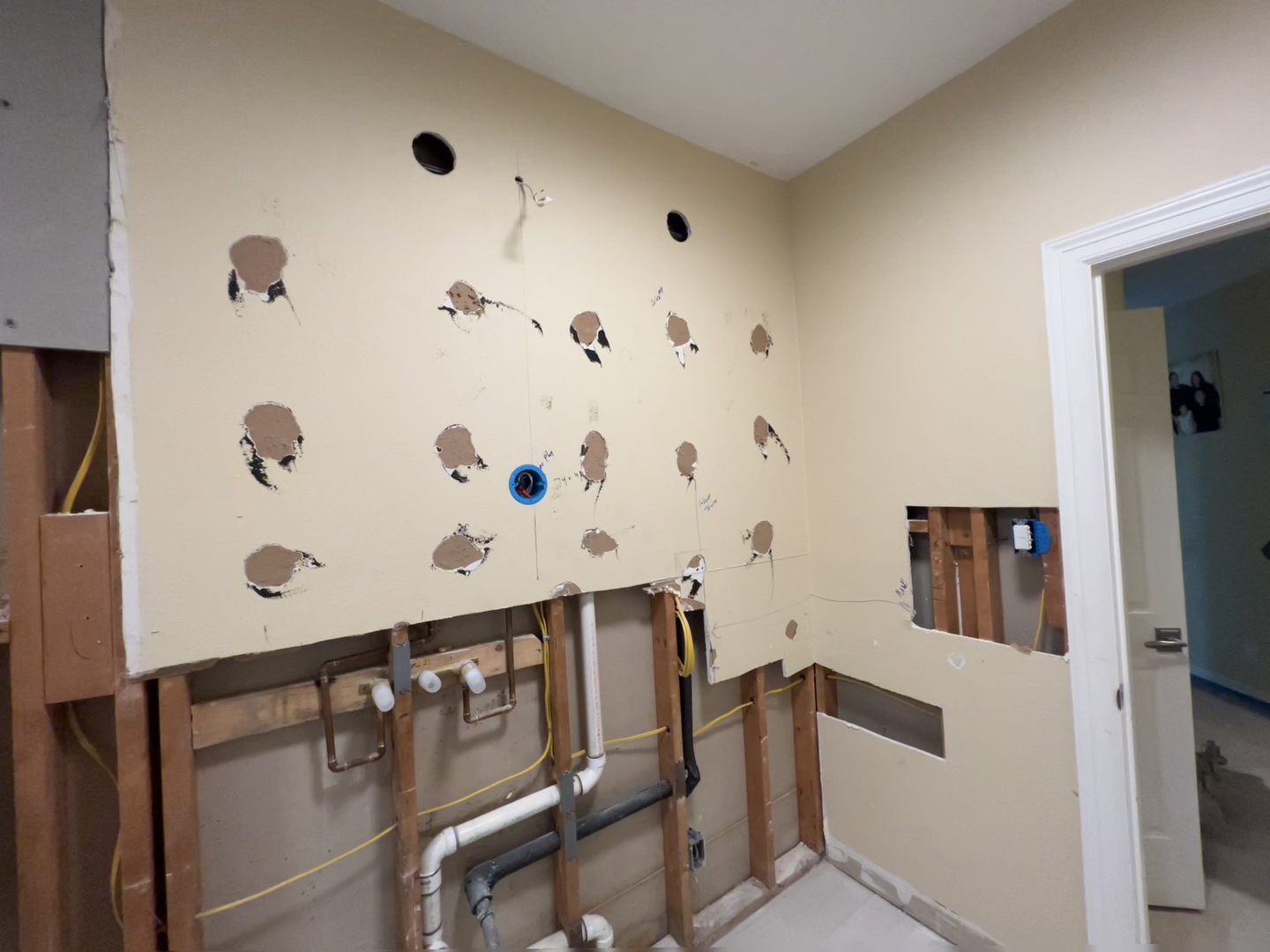 Bathroom remodel wall opened for electrical rough-in and fixture planning